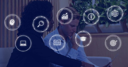 Image of network of connections with icons over diverse business people using laptop. Global...