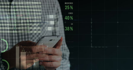 Image of financial data and graphs over hands of caucasian man using smartphone. Finance, economy,...