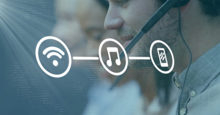 Image of media icons over diverse business people using phone headsets in office. Global business, technology and digital interface concept, digitally generated image.の写真素材