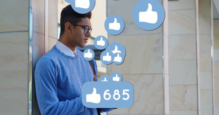 Side view on a Hispanic man wearing glasses is standing behind number of likes and floating like...