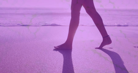 Digital waves against low section of woman walking on the beach. Travel and vacation conceptの写真素材