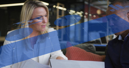 Image of infographic interface and diverse colleagues discussing over laptop in office. Digital composite, business, report, progress, teamwork, planning, smiling, technology.の写真素材