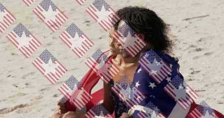 Image of usa flags over diverse women sitting on beach. presidents day, independence day and american patriotism concept digitally generated image.の写真素材