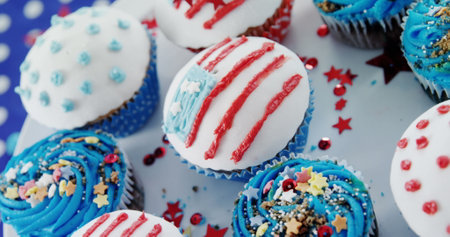 Image of usa flags and white and red stripes over cupcakes. presidents day, independence day and american patriotism concept digitally generated image.の写真素材