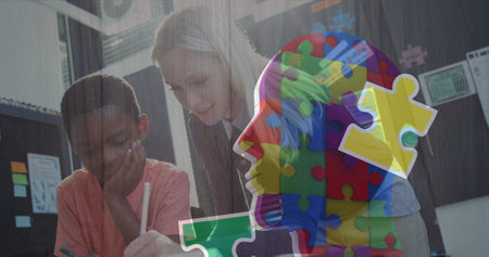 Image of puzzle pieces over diverse schoolchildren and teacher. autism awareness month and celebration concept digitally generated image.の写真素材