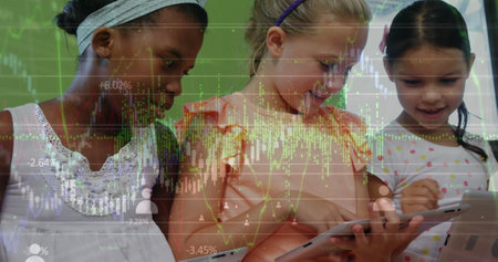 Image of graphs and financial data over diverse girls using tablet in classroom. School, education, learning with technology and finance concept digitally generated image.の写真素材