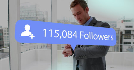 Image of digital interface Followers text and people icon with growing numbers on blue speech bubble over man using smartwatch. Global social media network digitally generated image.の写真素材