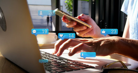 Image of social media icons falling over person using laptop. Social media and communication concept...