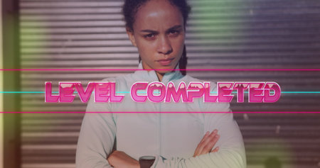 Image of level completed text over biracial woman with arms crossed. health and fitness concept...