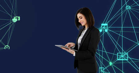 Caucasian professional woman using tablet with digital interface. She has brown hair, wearing black...