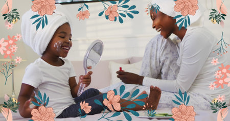 Image of pink flowers over happy african american mother and daughter using beauty products. family, togetherness, health and wellbeing concept digitally generated image.の写真素材