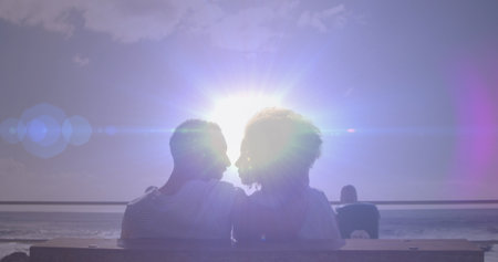 Bright spot of light against african american couple kissing each other at the beach. Love and relationship conceptの写真素材