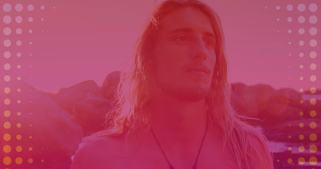 Abstract colorful shapes against caucasian man walking on the rocks near the sea. Travel and vacation conceptの写真素材