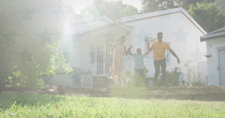 African American family walking outside, holding hands. They all have dark hair, young adult male wearing casual shirt and jeansの写真素材