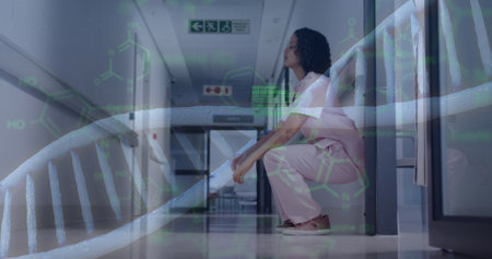 Image of dna strand and data processing over tired biracial female doctor. Global healthcare, science, medicine, research, computing and data processing concept digitally generated image.の写真素材