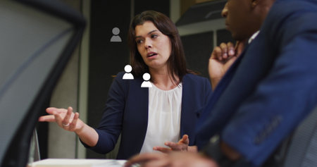 Image of media icons over diverse business people in office. Global business and digital interface concept digitally generated image.の写真素材