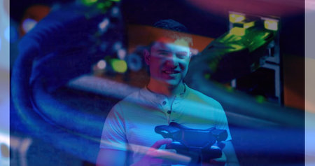 A young Caucasian adult male is holding virtual reality headset. He has short brown hair, a light...