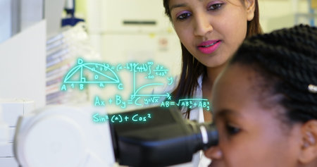 Image of mathematical equations over diverse female doctors using microscope. Global science and...