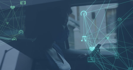 Image of network of media icons over african american woman using smartphone in car. global communication technology and social network concept digitally generated image.の写真素材