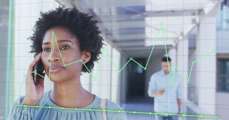 Image of financial data processing over african american businesswoman talking on smartphone. Global...