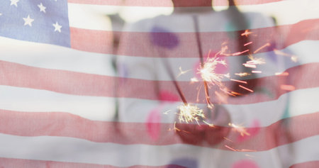 Image of flag of united states of america over biracial girl holding cupcake by seaside. American patriotism, diversity and tradition concept digitally generated image.の写真素材