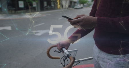 5g text and networking against mid section of man with bicycle using smartphone on the street. global networking and technology conceptの写真素材