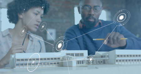 Image of network of connections over diverse colleagues discussing with model in office. Global...