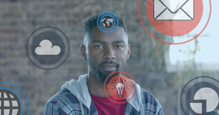Image of media icons over happy african american businessman in office. Global business, technology and digital interface concept digitally generated image.の写真素材