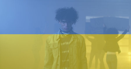 Image of flag of ukraine over african american male protester. ukraine crisis and international politics concept digitally generated image.の写真素材