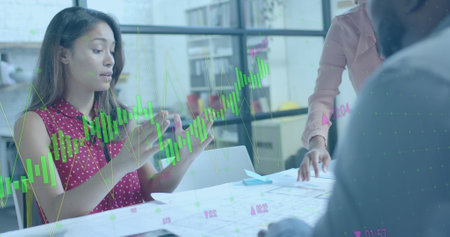 Data processing on interface over biracial female architect discussing with colleagues....