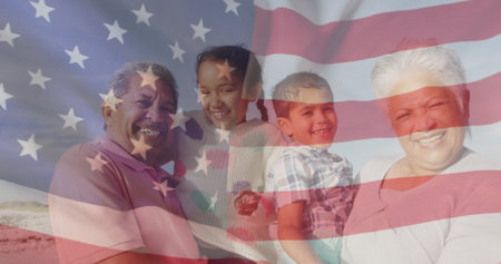 Image of flag of united states of america over biracial couple with grandchildren on beach. American patriotism, diversity and tradition concept digitally generated image.の写真素材