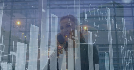 Image of financial graph over happy caucasian businesswomen using smartphone. Business, finance,...