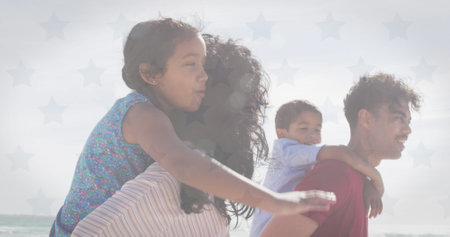 Image of flag of united states of america over biracial couple with son and daughter piggyback....
