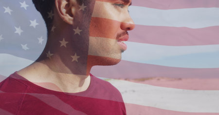 Image of flag of united states of america and biracial man on beach. American patriotism, diversity...