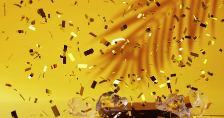 Image of confetti falling and cocktail on yellow background. Party, drink, entertainment and celebration concept digitally generated image.の写真素材