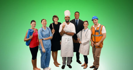 Image of group of professionals smiling over green background. global business, finances and technology concept digitally generated image.の写真素材