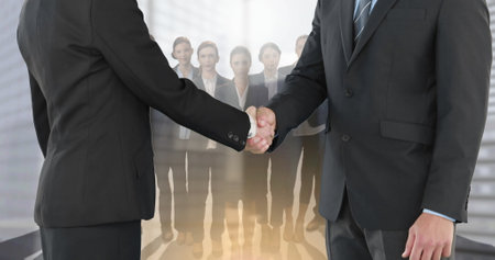 Image of businessman and businesswoman shaking hands over group of businesspeople. global business, finances and networking concept digitally generated image.の写真素材