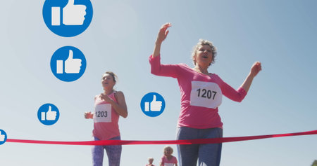 Image of social media thumbs up like symbols, over female runners finishing race. social media,...