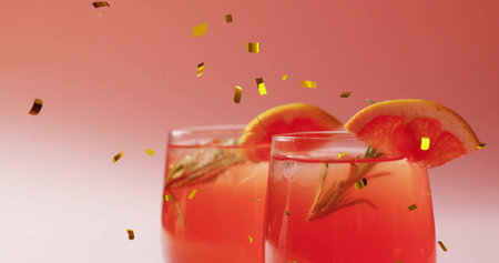 Image of confetti falling and cocktail on pink background. Party, drink, entertainment and...