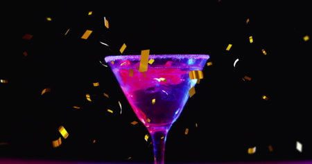 Image of confetti falling and cocktail on black background. Party, drink, entertainment and...