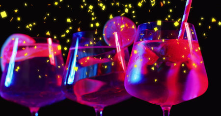 Image of confetti falling and cocktails on black background. Party, drink, entertainment and celebration concept digitally generated image.の写真素材