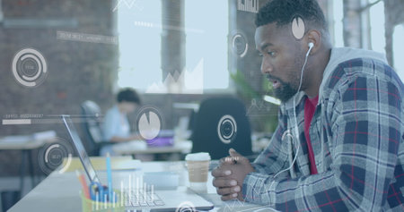 Image of data processing over african american businessman using laptop in office. Global business, technology and digital interface concept digitally generated image.の写真素材