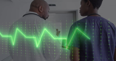 Image of vital signs reading over african american female and male doctor using tablet talking. Medical and healthcare services concept digitally generated image.の写真素材