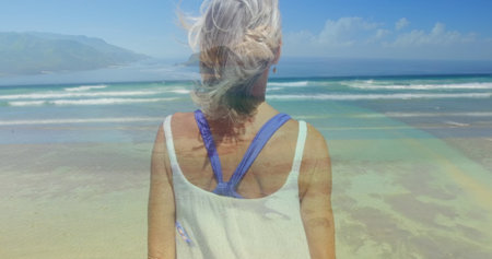 Rear view of a Caucasian woman on the beach  staring at the waves
