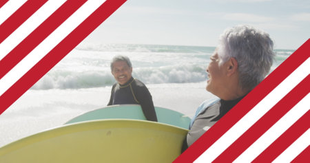Image of flag of united states of america over senior biracial couple with surfboard on beach....
