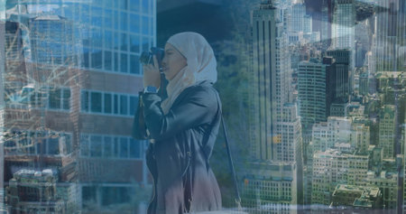 Image of asian woman in hijab with camera over cityscape. out and about in the city, digitally...