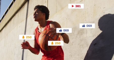 Image of media icons over african american man with basketball. Global business and digital...