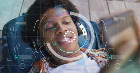 Image of data processing over african american man using smartphone. Global business and digital interface concept digitally generated image.の写真素材