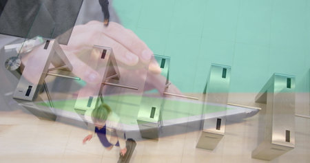 Image of hands using tablet over businesswomen walking through turnstiles. business and...