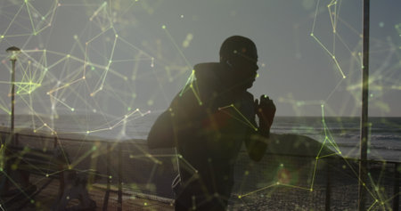 Image of network of connections over a running african american man. Global connections, wellbeing, fitness and healthy lifestyle concept digitally generated image.の写真素材